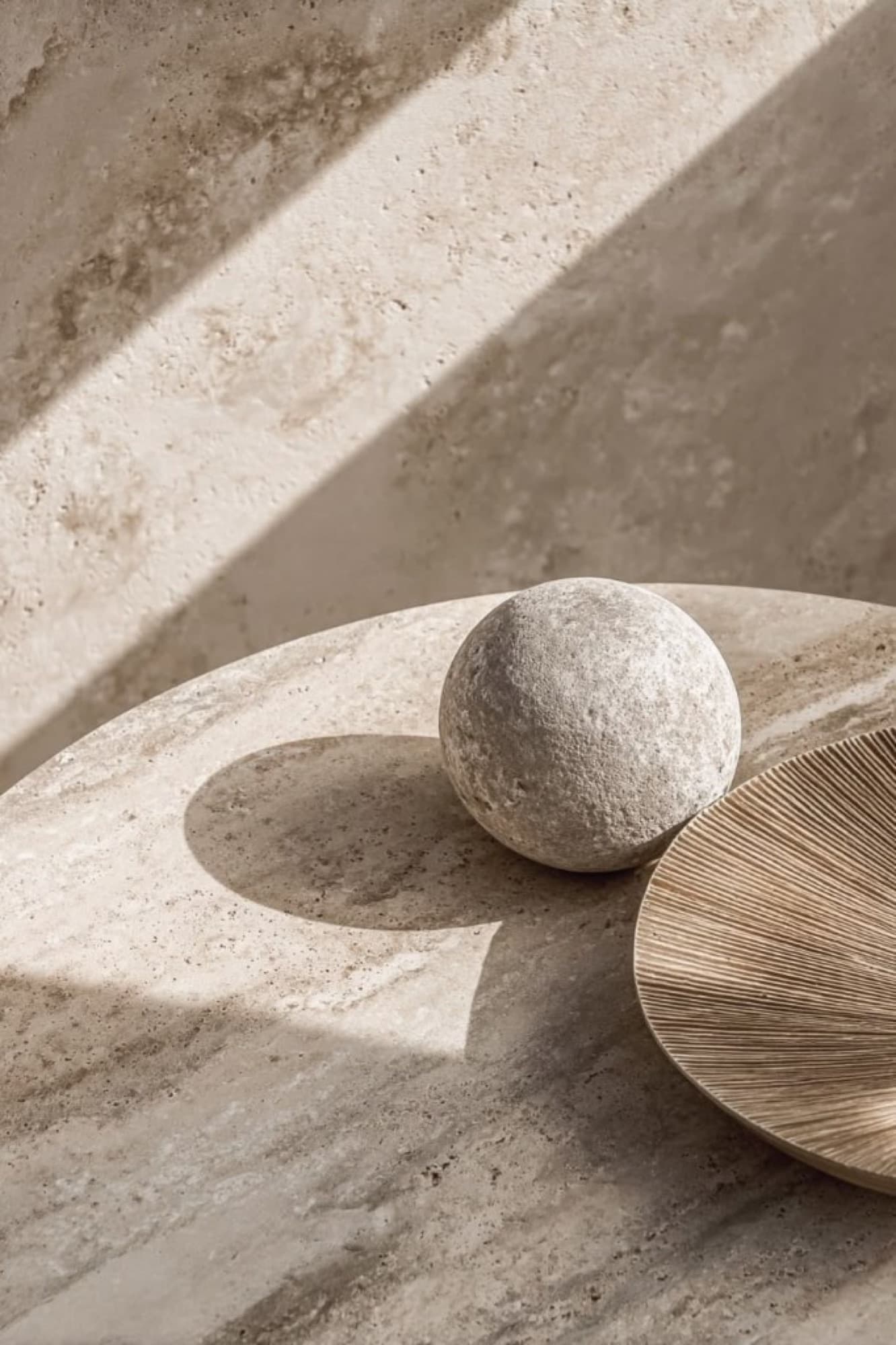 Esfera de pedra sobre travertino.